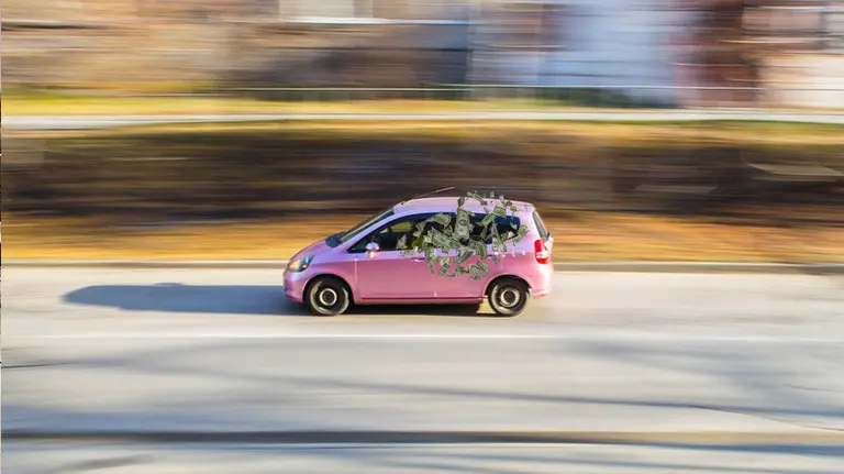 Imagen de un coche y varios billetes saliendo de la ventanilla FOTOMONTAJE