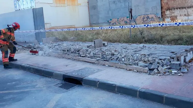 Bomberos trabaja limpiando la zona tras derrumbarse el muro. POLÍCIA LOCAL DE CASTELLÓN