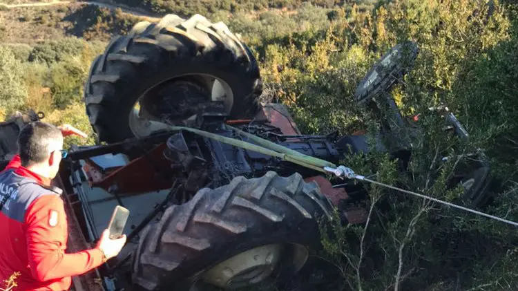 Un policía foral junto al tractor volcado bajo el que ha quedado atrapado un vecino de  81 años en Cáseda.