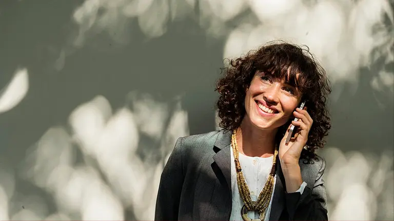 Una mujer habla por teléfono móvil