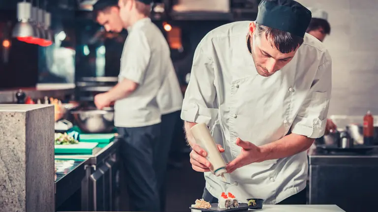 Imagen de un cocinero emplatando un plato de sushi ARCHIVO