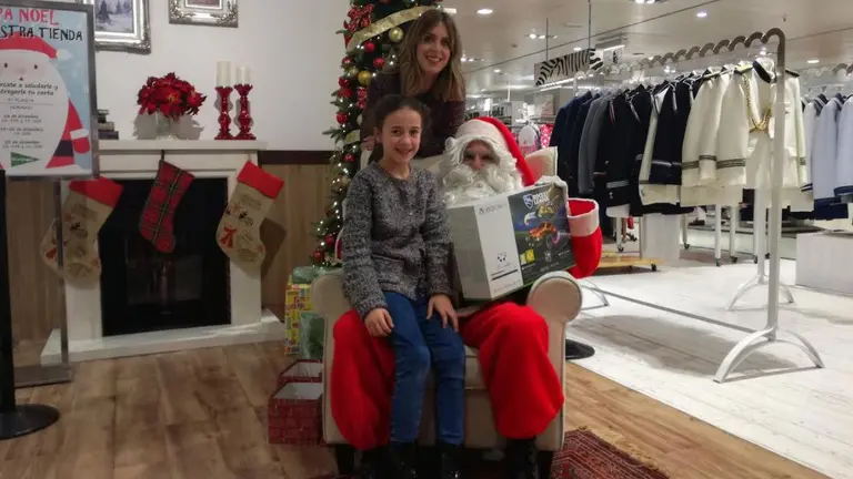 Fátima Idaira Cortejosa recibe su regalo de manos de Papá Noel. En la imagen aparece también María Oset, de marketing de El Corte Inglés CEDIDA