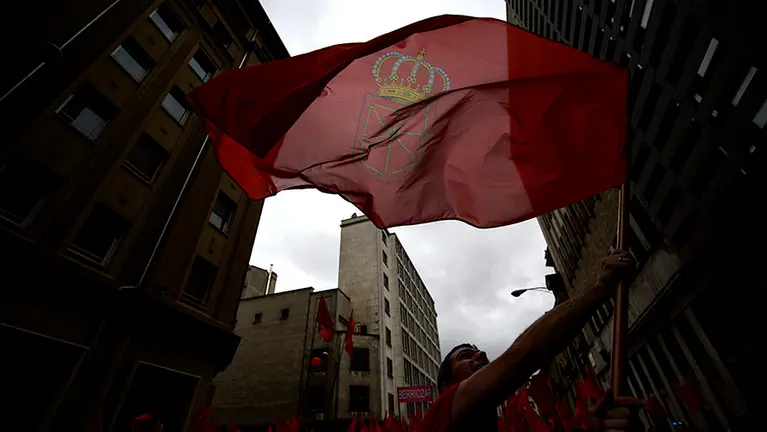 Un hombre hondea una bandera de Navarra durante la manifestación del 3 de junio bajo el lema _Defendamos la bandera navarra_. PABLO LASAOSA