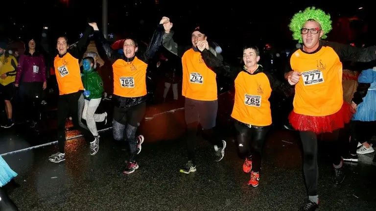 Algunos de los participantes de la San Silvestre de Burlada ataviados con sus disfraces y desafiando a la lluvia