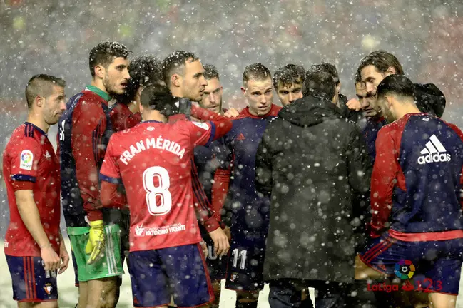 Los jugadores de Osasuna reunidos bajo la nieve en El Sadar. La Liga.