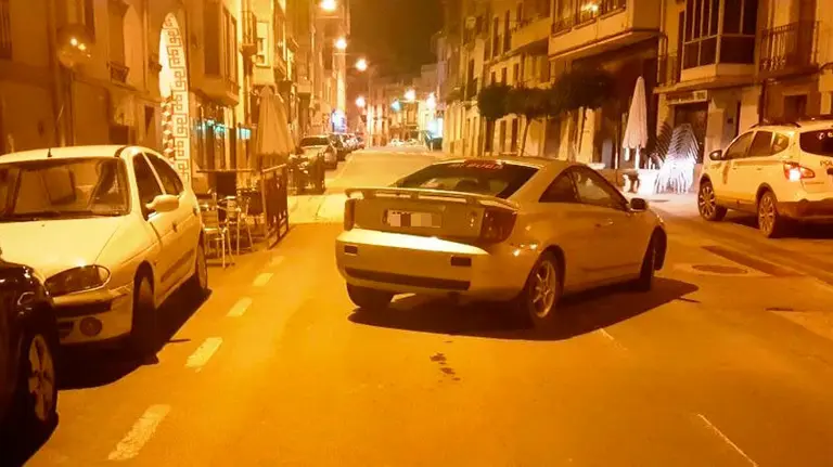 El vehículo cruzado en una calle de Peralta tras chocar contra varios coches aparcados. POLICÍA FORAL