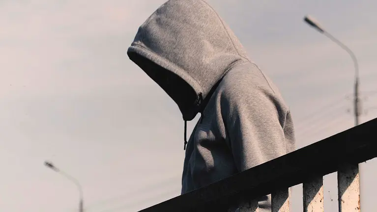 Una persona oculta su rostro tras participar en una pelea. ARCHIVO