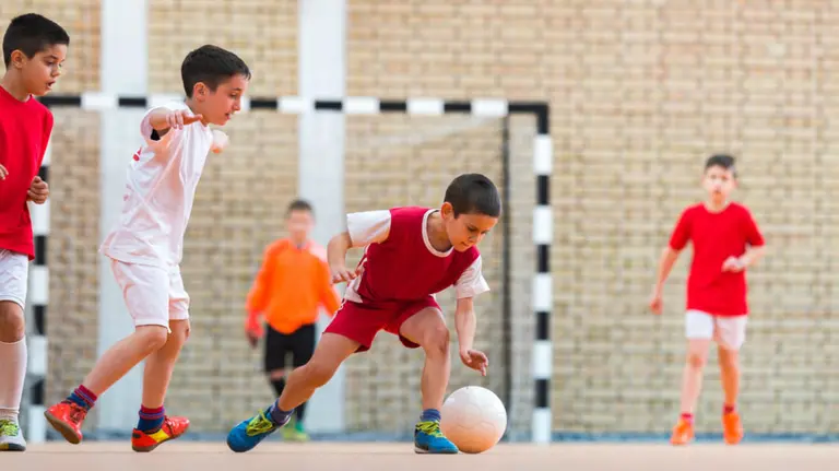 Unos niños juegan a fútbol en el patio de un colegio ARCHIVO