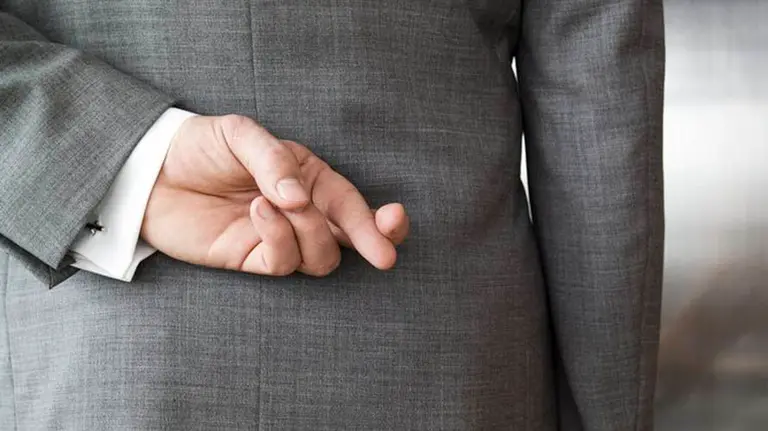 Un hombre cruza los dedos