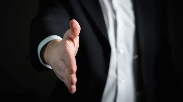 Un director de una empresa cierra un trato con un apretón de mano. ARCHIVO