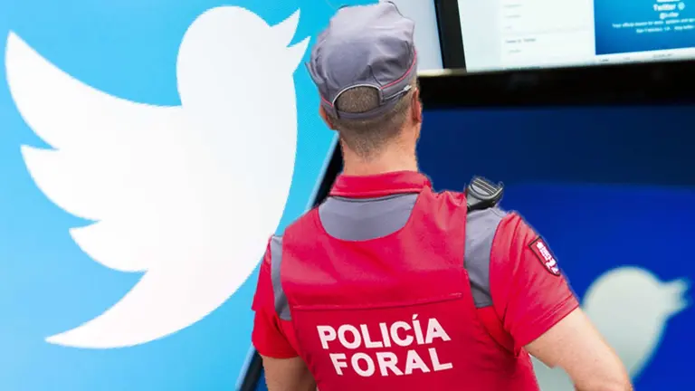 Un agente de la Policía Foral sobre un fondo de la red social Twitter..