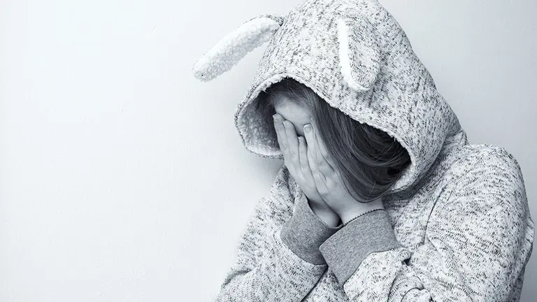 Una niña se protege del acoso de otros compañeros en el colegio