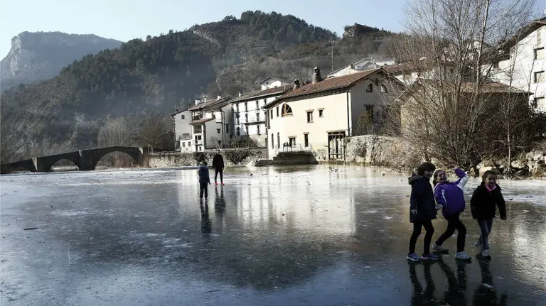 Tiempo. Un grupo de jóvenes juegan al balón sobre la superficie helada del Río Esca a su paso por la localidad navarra de Burgui. EFE. Jesús Diges  