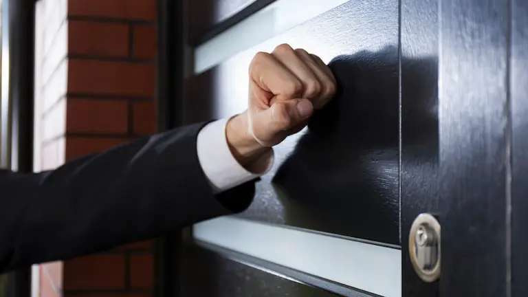 Close-up of hand knocking on the door