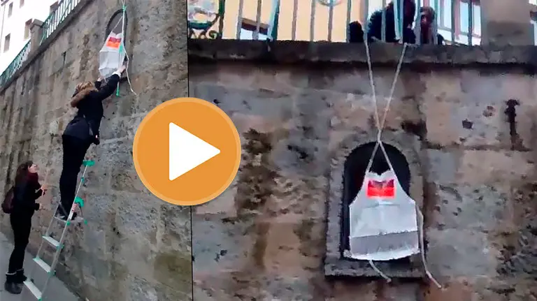 Sindicalistas de LAB cuelgan un delantal de la imagen de San Fermín colocada en la hornacina de la cuesta de Santo Domingo TWITTER