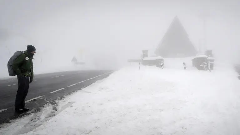 Un peregrino de California que realiza el Camino de Santiago observa como una máquina quitanieves retira la nieve acumulada en la N135 en el Alto de Ibañeta (Navarra), donde el último temporal de nieve, frío y viento ha acumulado espesores de hasta 30 cm y mantiene a toda la comunidad Foral en alerta. EFE/Villar López