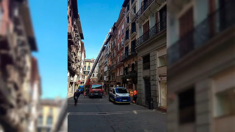 Los bomberos atienden la caída de un alero en un tejado de la calle Chapitala, en Pamplona. POLICÍA MUNICIPAL
