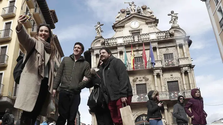 GRAF2469. PAMPLONA (ESPAÑA), 29/03/2018.- Un grupo de turistas se fotografían con el Ayuntamiento de Pamplona tras ellos, en una jornada festiva donde la comunidad foral es uno de los lugares preferidos para pasar estos días de Semana Santa. La AEMET anuncia para hoy en Navarra cielos cubiertos con precipitaciones débiles en el tercio norte donde los claros se irán abriendo a lo largo de la jornada. EFE/Jesús Diges