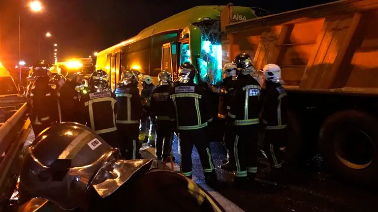 Los bomberos trabajan en la excarcelación del conductor del autobús, que ha quedado atrapado tras el impacto. EMERGENCIAS DE MADRID