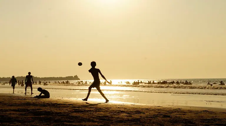 Varios niños juegan al fútbol en la playa ARCHIVO
