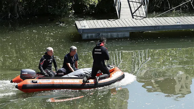 GRA180. PAMPLONA, 24/05/2017.- Varios bomberos sobre una lancha trasladan el cadáver que ha sido hallado esta mañana en el río Arga a su paso por la avenida Guipúzcoa de Pamplona, junto al Puente de Santa Engracia. La policía foral que se encarga de las investigaciones para la identificación del cadáver, señala que hacia las 11,06 horas de hoy se ha encontrado en el agua, junto a la presa, un cadáver boca abajo. Han acudido al lugar unidades de los servicios de emergencias, Policía Judicial y Policía Foral. EFE/Jesús Diges