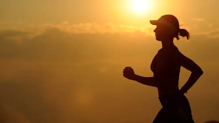Una mujer practicando deporte al atardecer