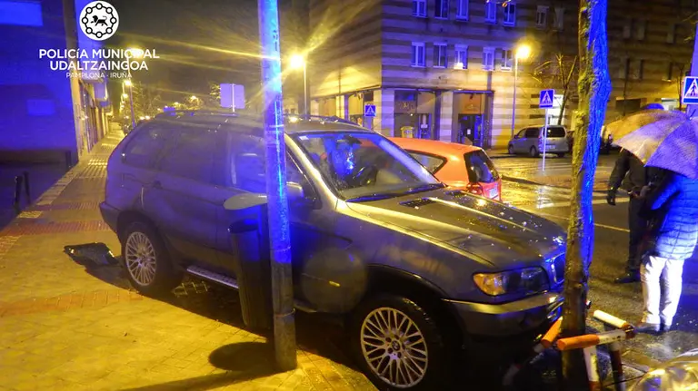 Un joven herido tras chocar contra otro coche que estaba aparcado en Mendillorri y que terminó subido en la acera. POLICÍA MUNICIPAL