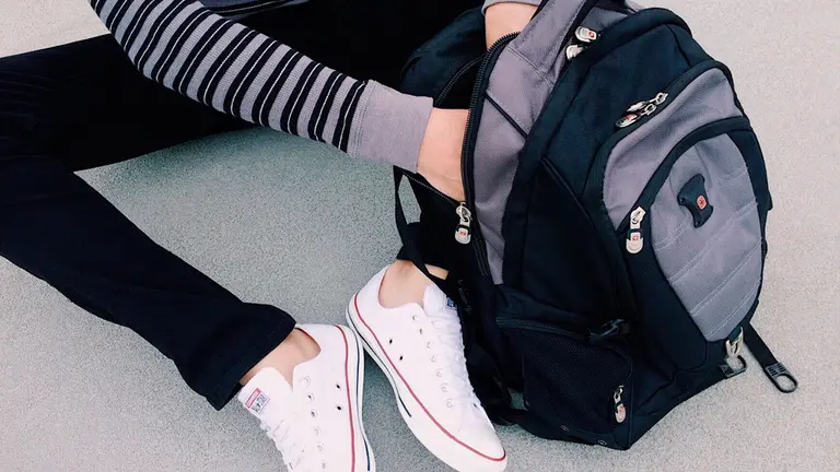 Una chica tirada en el suelo con su mochila. ARCHIVO