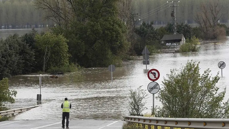 Una persona toma imágenes de la carretera N-113 que permanece cortada hacia Castejón tras el desbordamiento del Rio Ebro.La alerta por inundaciones se mantiene a estas horas en Navarra en dos estaciones de aforo, la del Ebro en Castejón y la del Ega en Andosilla, mientras que en Pamplona desciende el caudal de los ríos y se va recuperando la normalidad tras los desbordamientos de ayer. EFE/ Jesús Diges