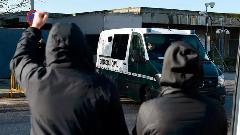 Dos personas encapuchadas se concentran a las puertas de la Audiencia Nacional para recibir el furgón que trae a los acusados por el caso Alsasua. EFE/Fernando Villar.