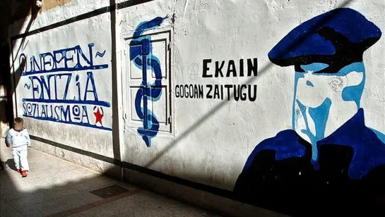 Un menor de edad pasea junto a una de las muchas pintadas en favor de ETA que aún perduran.