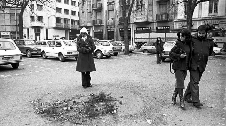 Varias personas pasan por el lugar donde fue abatido Joaquín Ímaz en Pamplona. JNC-RELATOS DE PLOMO