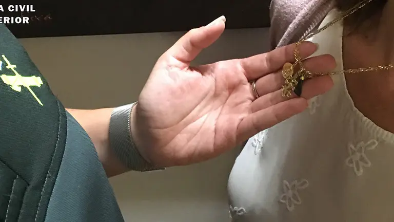 Un guardia civil comprueba un collar de oro que lleva puesto una mujer GUARDIA CIVIL