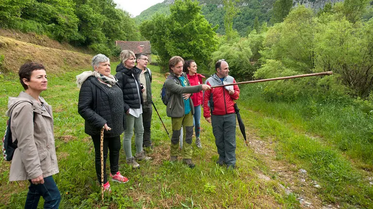 Ayerdi atiende las explicaciones del gu&iacute;a Koldo Villalva, en el sendero de Aribe. GOBIERNO DE NAVARRA