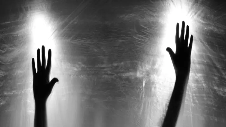 Manos contra un cristal.