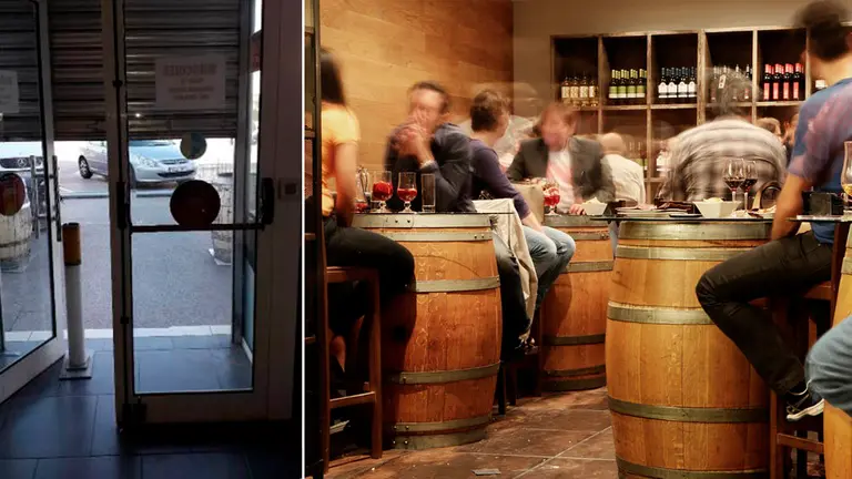 Imagen de archivo de la persiana de un bar bajada junto a un local de hostelería con varios clientes ARCHIVO