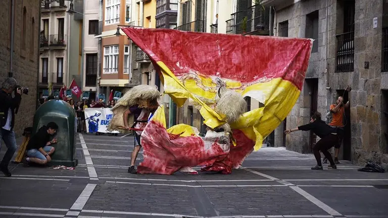 Rompen una enorme bandera de España con el escudo franquista durante la manifestación realizada por Ernai en Pamplona por la libertad de los agresores de Alsasua. PABLO LASAOSA