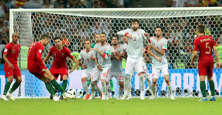 Sochi (Russian Federation), 15/06/2018.- Cristiano Ronaldo (2-L) of Portugal converts a free kick to score the 3-3 equalizer during the FIFA World Cup 2018 group B preliminary round soccer match between Portugal and Spain in Sochi, Russia, 15 June 2018. (RESTRICTIONS APPLY: Editorial Use Only, not used in association with any commercial entity - Images must not be used in any form of alert service or push service of any kind including via mobile alert services, downloads to mobile devices or MMS messaging - Images must appear as still images and must not emulate match action video footage - No alteration is made to, and no text or image is superimposed over, any published image which: (a) intentionally obscures or removes a sponsor identification image; or (b) adds or overlays the commercial identification of any third party which is not officially associated with the FIFA World Cup) (España, Mundial de Fútbol, Rusia) EFE/EPA/FRIEDEMANN VOGEL EDITORIAL USE ONLY
