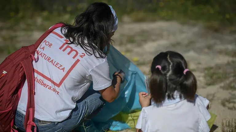 Dos voluntarias recogen basura en un espacio natural CEDIDA