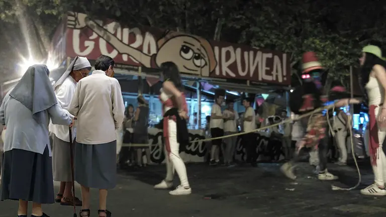 Imagen de varias monjas junto a una de las fotografías de las txoznas de Gora Iruñea en los pasados Sanfermines FOTOMONTAJE