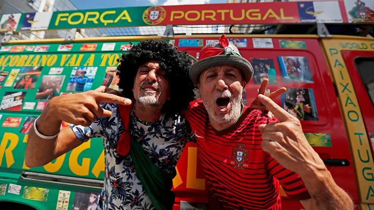 PO6002JPG. SARANSK (RUSIA), 23/06/2018.- Carlos Brum de 61 (d) y Luis Lobito de 60 años, aficionados de la selección de Portugal, posan junto a su furgoneta en Saransk, Rusia, hoy, 23 de junio de 2018. Carlos y Luis viajan en furgoneta desde Lisboa a las ciudades donde los portugueses juegan en la Copa del Mundo de Rusia 2018, en cada lugar paran y venden camisolas y bufandas de la selección para pagar la gasolina y la comida. EFE/Esteban Biba
