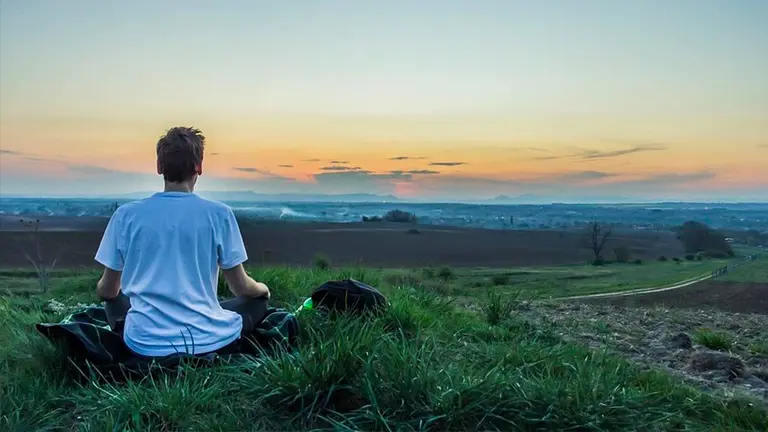 Un joven medita en el campo