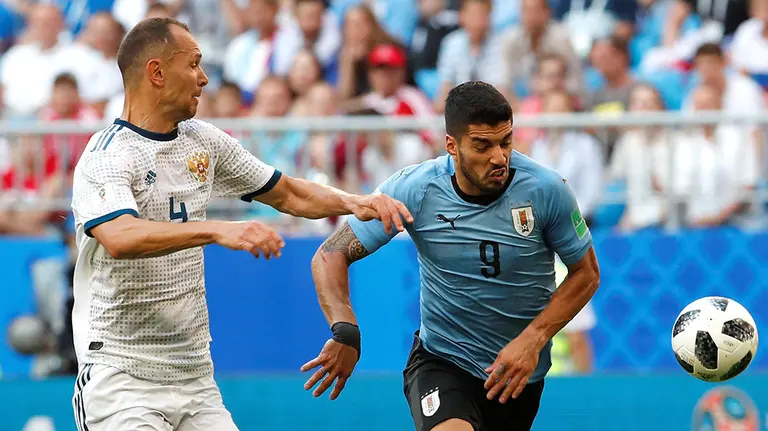El delantero uruguayo Luis Su&aacute;rez (d) y el defensa ruso Sergey Ignashevich, durante el partido Uruguay-Rusia, del Mundial de F&uacute;tbol de Rusia 2018, en el Samara Arena. EFE.