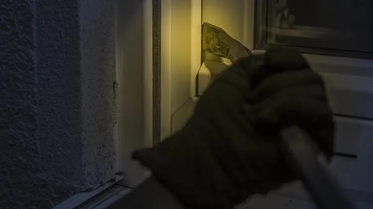 Un hombre tratando de acceder al interior de una vivienda