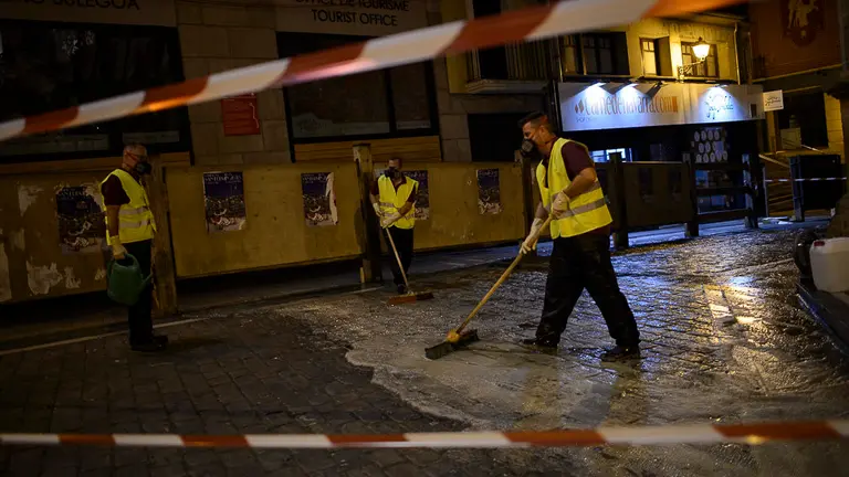 Operarios rocían liquido antideslizante en el recorrido del encierro de San Fermín. PABLO LASAOSA 07