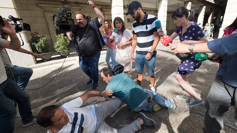 ANDALUCÍA. SEV02. SEVILLA, 05/07/2018.- Antonio Manuel Guerrero (C), el guardia civil miembro de La Manada, condenado a 9 años de cárcel por abusos sexuales a una joven en los Sanfermines de 2016, a su salida de la Audiencia de Sevilla donde se ha celebrado una vista por videoconferencia con la Audiencia de Navarra que ha durado cuatro horas y media para decidir si vuelve a prisión tras intentar renovar el pasaporte. (Unos cámaras han tropezado y se han caído delante)EFE/ Pepo Herrera