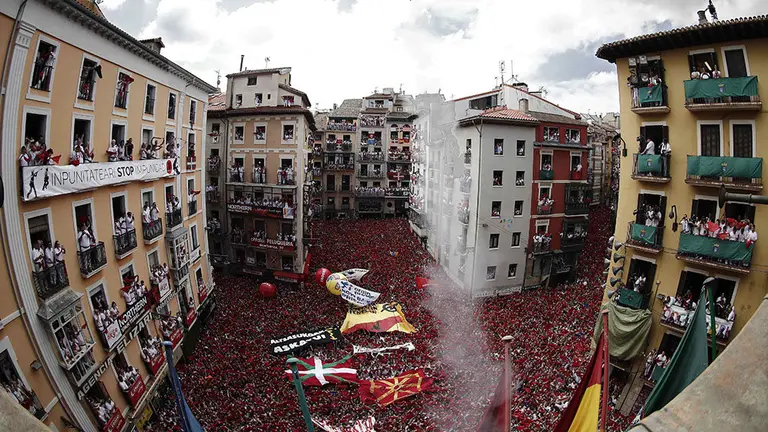 Miles de personas celebran el comienzo de las fiestas de San Ferm&iacute;n, que como todos los a&ntilde;os comienza en la plaza del Ayuntamiento con el tradicional "txupinazo" desde la casa consistorial.- EFE/Jes&uacute;s Diges