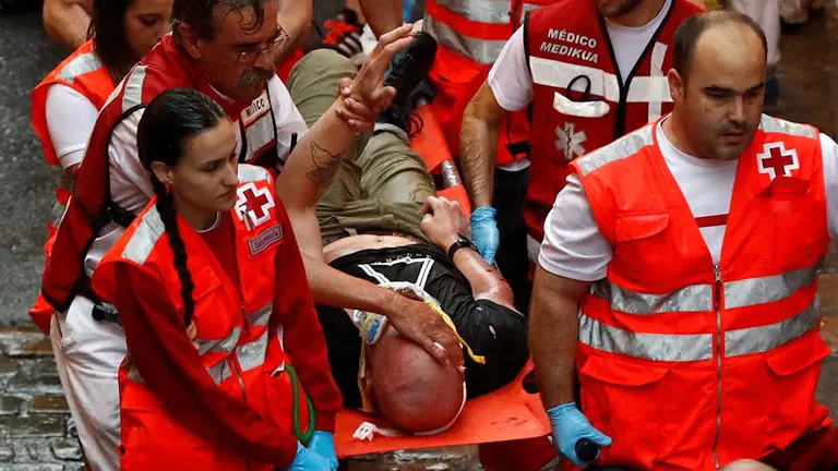 GRAF5850. PAMPLONA (ESPAÑA), 08/07/2018.-Los servicios médicos trasladan a un herido en la cuesta de Santo Domingo, tras el segundo encierro de los Sanfermines 2018 protagonizado por los toros de la ganadería de José Escolar Gil (Ávila), donde la lluvia y un toro rezagado desde Santo Domingo han caracterizado la carrera. EFE/Villar López