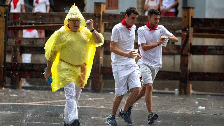 GRAF5669. PAMPLONA, 07/07/2018.- La lluvia ha sorprendido a las peñas y charangas, momentos antes del inicio de la primera corrida de toros de la fiestas de San Fermín, en Pamplona. EFE/Rodrigo Jiménez