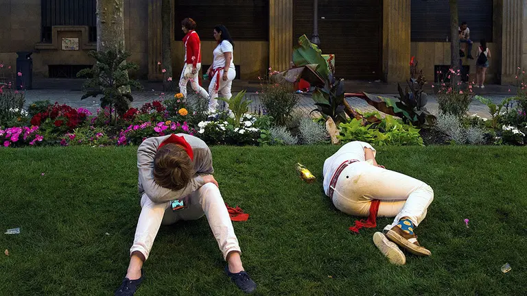 GRAF5866. PAMPLONA (ESPAÑA), 08/07/2018.-Numerosas personas buscan un lugar en parques y jardines de la ciudad, para descansar y dormir después de una noche de fiesta de San Fermín en Pamplona.- EFE/Rodrigo Jiménez